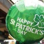 A festive St. Patrick's Day celebration with people dressed in green, featuring traditional Irish decorations and food.